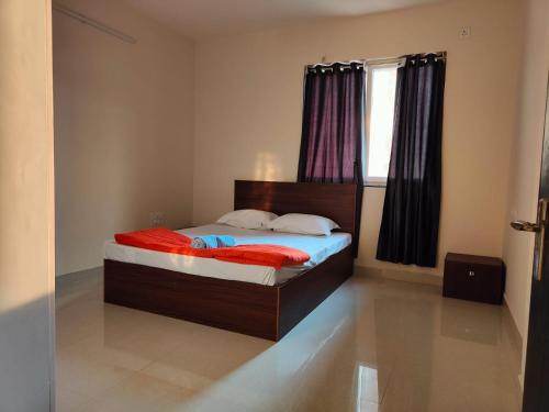 a bedroom with a bed with red sheets and a window at Astonishing 3BHK at 6-Floor for Family only in Bengaluru
