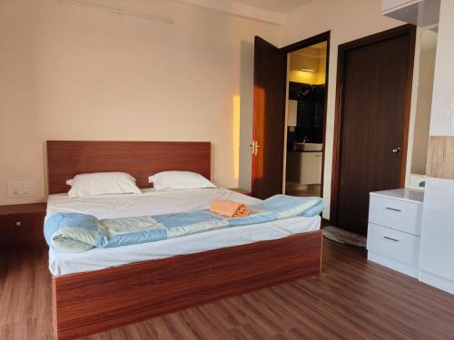 a bedroom with a large bed with a wooden headboard at Astonishing 3BHK at 6-Floor for Family only in Bengaluru