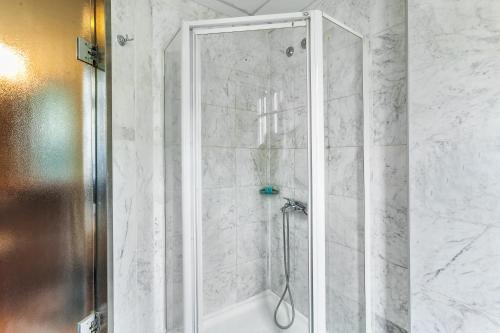 a shower with a glass door in a bathroom at Minerva Premier Hotel in Thessaloniki
