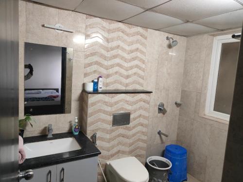 a bathroom with a sink and a toilet and a mirror at Astonishing 3BHK at 6-Floor for Family only in Bengaluru