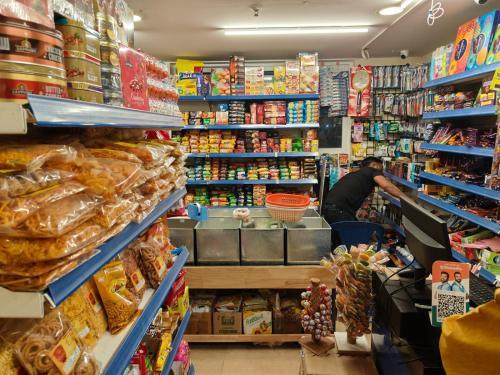a grocery store aisle with a man preparing food at Astonishing 3BHK at 6-Floor for Family only in Bengaluru