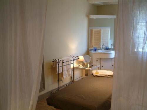 Dormitorio pequeño con cama y lavamanos en Chateau de Maumont en Magnac-sur-Touvre