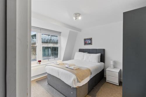 a white bedroom with a bed and a window at Modern Clerkenwell Loft Spacious Private Terrace in London