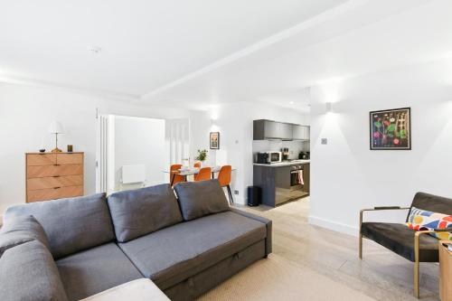 a living room with a couch and a kitchen at Modern Clerkenwell Loft Spacious Private Terrace in London