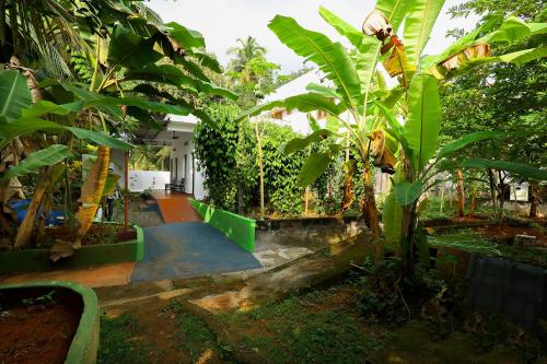 a house with a garden with banana trees at ILLIKKALAM Lakeside Cottages Kumarakom Kerala in Kumarakom