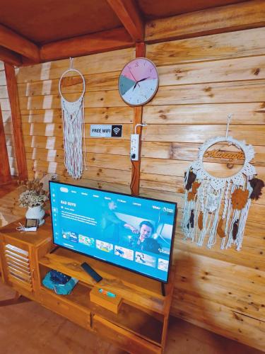 a tv on a wooden wall with a clock and a basketball hoop at miarzafa cabin house in Kejajar