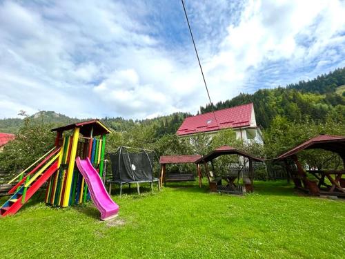 a group of playground equipment in a grass field at Casa Mădălina in Moieciu de Sus