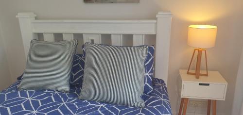 a bedroom with a bed with blue and white pillows at Tuggerah lakefront 4 bed 2 bath home with stunning views in Gorokan
