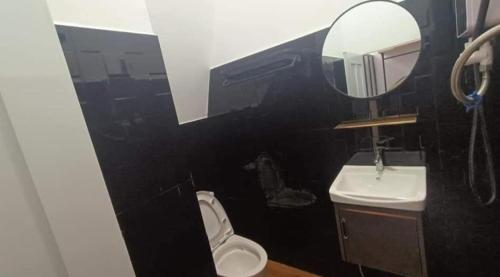 a bathroom with a sink and a toilet and a mirror at Little Susie Double Room with Balcony in Phnom Penh