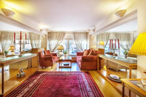 a living room with couches and a red rug at Minerva Premier Hotel in Thessaloniki