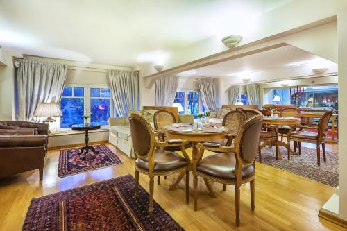 a dining room and living room with a table and chairs at Minerva Premier Hotel in Thessaloniki