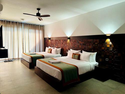 a hotel room with two beds and a ceiling fan at Ella Flower Garden Resort in Ella