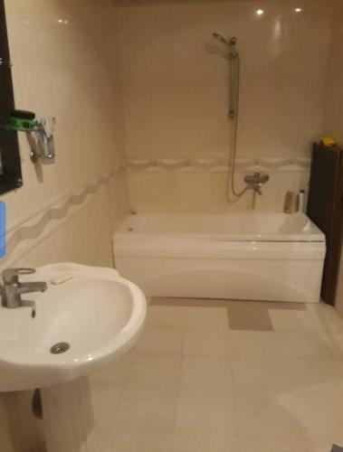 a bathroom with a sink and a shower and a tub at Sweet home in Karawang