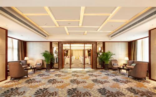 a lobby of a hotel with chairs and tables at Yiho Hotel Xiamen Huli in Xiamen