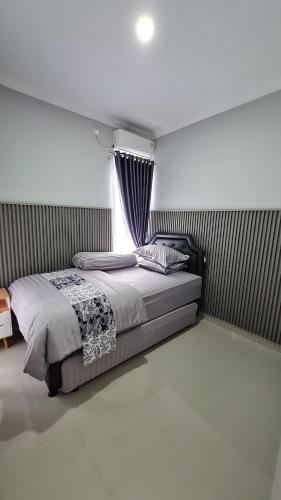 a bedroom with a bed and a window at Baturiti Modern Guest House with private pool in Salakan
