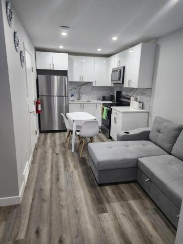 a living room with a couch and a table and a kitchen at lovely 2bed & 1 Bath Basement Suite for 4 guests in Calgary