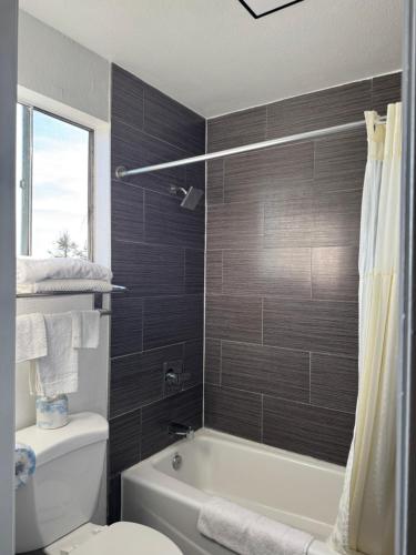a bathroom with a tub and a toilet and a sink at Rodeway Inn in Ventura