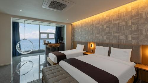 a hotel room with two beds and a window at Elafonisi Poolvilla & Hotel in Gyeongju