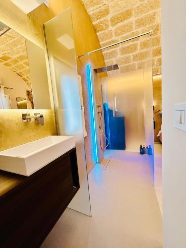 a bathroom with a sink and a glass shower at La Piazzetta Luxury Rooms in Polignano a Mare