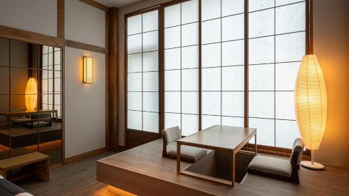 a room with a table and chairs and a large window at Elafonisi Poolvilla & Hotel in Gyeongju