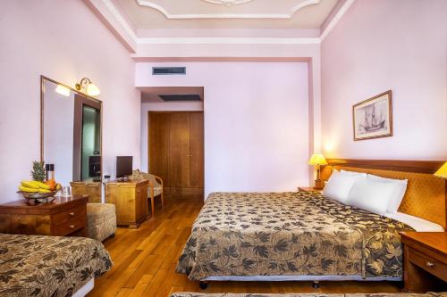 a hotel room with a bed and a mirror at Minerva Premier Hotel in Thessaloniki