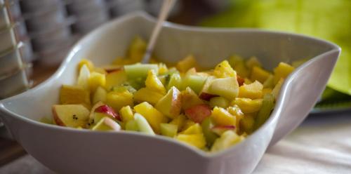 a white bowl of fruit with a spoon in it at Panoramagasthof auf dem Auerberg in Bernbeuren