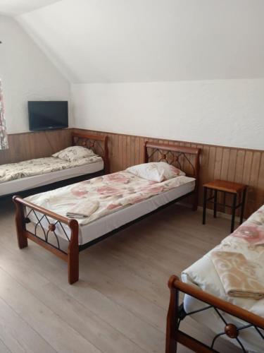 a room with three beds and a table at Svečių namai Alėjos Ąžuolas in Druskininkai