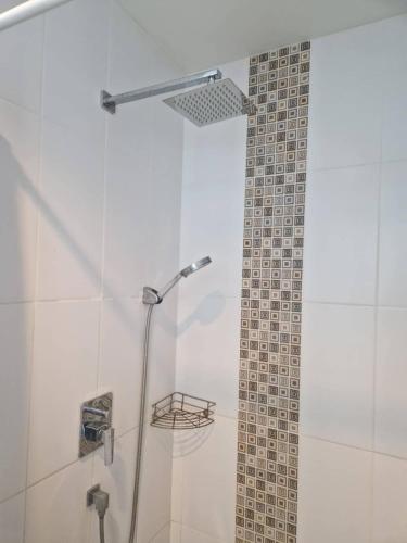 a shower in a bathroom with a tile wall at Grandblue condominium 602 in Ban Tha Fat