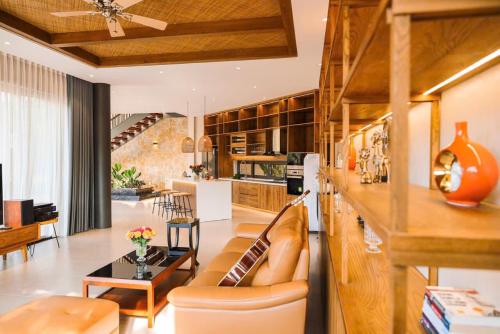 ein Wohnzimmer mit Sofa und Tisch in der Unterkunft Villa Brisa Tropical BMT in Buôn Kao