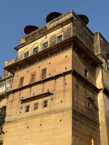 a large brick building with a tower at Rana Mahal - a Boutique Place in Varanasi