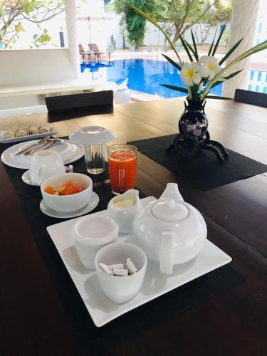 a table with a tray with bowls and plates of food at Blue Kite Retreat in Kalpitiya