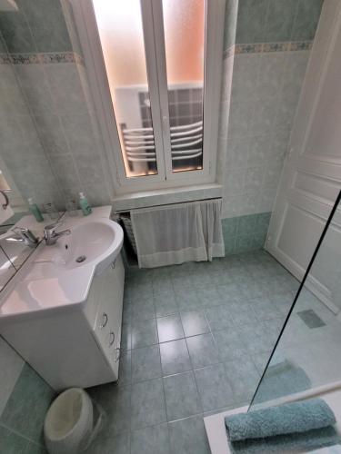 une salle de bain blanche avec un lavabo et une fenêtre dans l'établissement CASINO FLAT Center, à Beausoleil