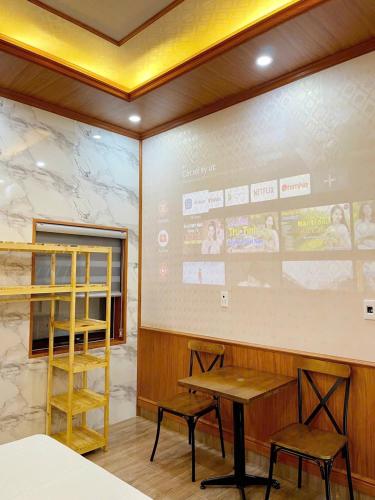 a room with a table and two chairs and a screen at BinBin Homestay Đồng Hới Quảng Bình in Dong Hoi