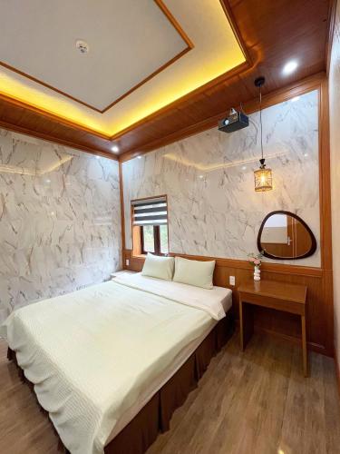 a small bedroom with a bed and a mirror at BinBin Homestay Đồng Hới Quảng Bình in Dong Hoi