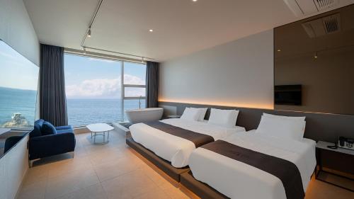 a hotel room with two beds and a large window at Elafonisi Poolvilla & Hotel in Gyeongju