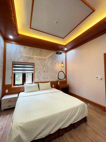 a bedroom with a large white bed with a ceiling at BinBin Homestay Đồng Hới Quảng Bình in Dong Hoi