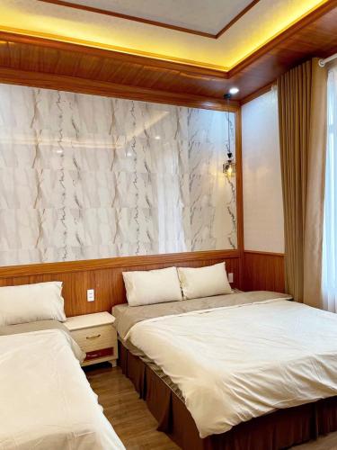 a bedroom with two beds and a window at BinBin Homestay Đồng Hới Quảng Bình in Dong Hoi