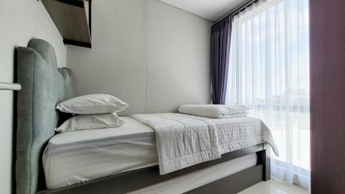 a bed in a room with a window at Palam Mansion at Apartment One Residence in Batam Center