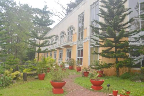 a building with potted plants in front of it at Hotel Elizabeth - Baguio in Baguio