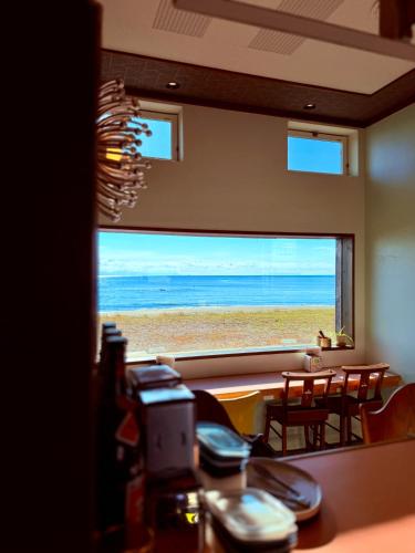 a room with a view of the beach through a window at Seaside Inn KOKOMO in Hakodate
