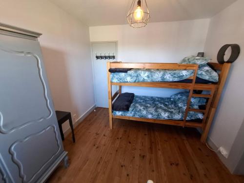 une chambre avec deux lits superposés dans une pièce dans l'établissement Maison proche Hauteville-sur-mer, à Le Grand Cambry