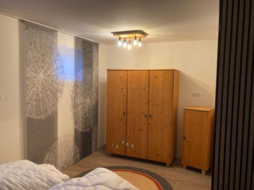 a bedroom with a bed and a wooden cabinet at Ferienwohnung Schreiner Innblick in Wernstein am Inn