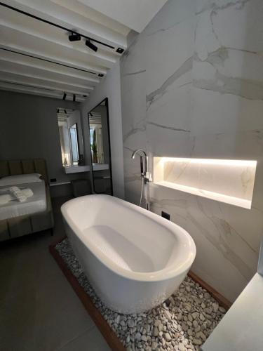 a white bath tub in a bathroom with a marble wall at Sea View Luxury Apartment in Vlorë