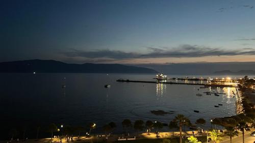 a large body of water at night with a pier at Sea View Luxury Apartment in Vlorë