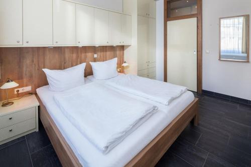 ノルダーナイにあるFerienwohnung Strandhafer Norderneyのベッドルーム(白いシーツを使用した大型ベッド1台付)
