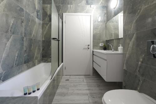 a bathroom with a tub and a toilet and a sink at לוי-קיישן מגוון דירות גן ופנטהאוזים וסוויטות נוף ברחוב הצנחנים in Tiberias