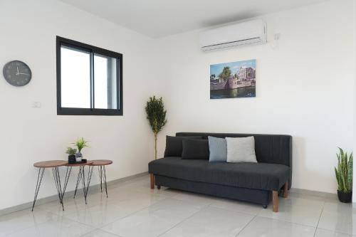 a living room with a couch and a table at לוי-קיישן מגוון דירות גן ופנטהאוזים וסוויטות נוף ברחוב הצנחנים in Tiberias