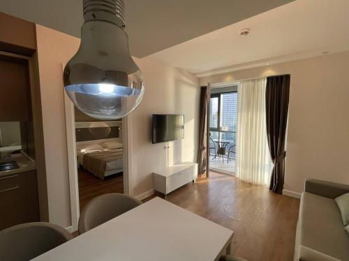 a living room with a table and a large light at Skyline Apartments Batumi in Batumi