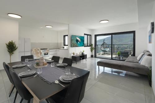 a dining room and living room with a table and chairs at לוי-קיישן מגוון דירות גן ופנטהאוזים וסוויטות נוף ברחוב הצנחנים in Tiberias