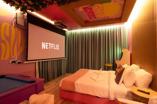 a hotel room with a bed and a projection screen at Capsule Flora business bay view Burj Khalifa-pool table-game arcade-Projector-Playstation 5 in Dubai